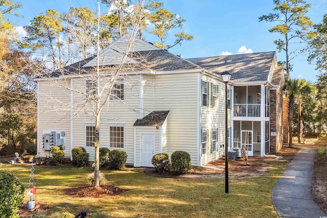 view of side of home with a sunroom, central AC, and a lawn