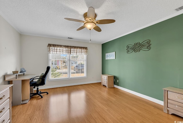 office space with a textured ceiling, ornamental molding, light hardwood / wood-style floors, and ceiling fan