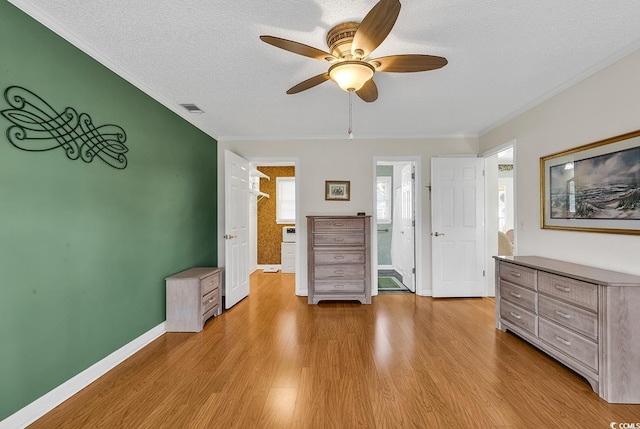 interior space with crown molding, ceiling fan, a textured ceiling, and light wood-type flooring