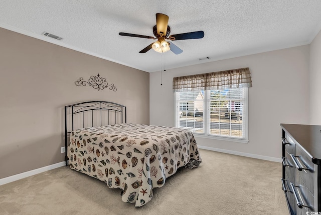 carpeted bedroom featuring ceiling fan and a textured ceiling