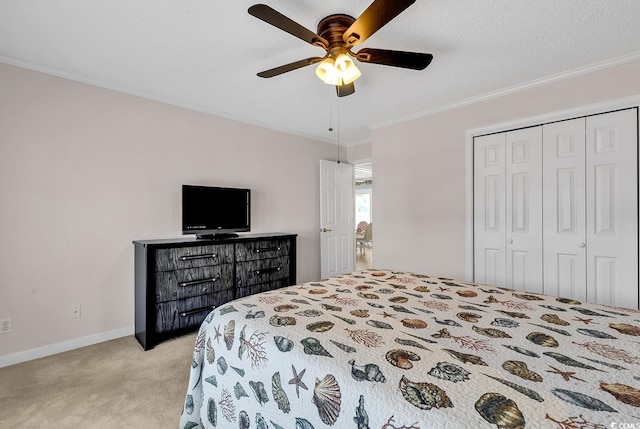 carpeted bedroom with ceiling fan, crown molding, a closet, and a textured ceiling