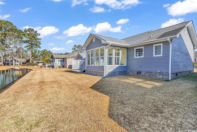 rear view of property featuring a lawn