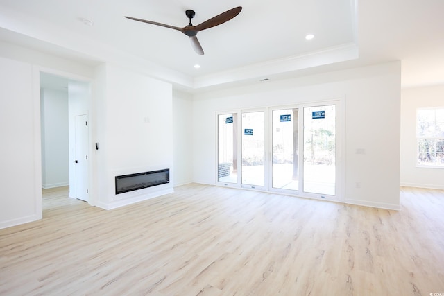 unfurnished living room with crown molding, light hardwood / wood-style floors, a raised ceiling, and ceiling fan