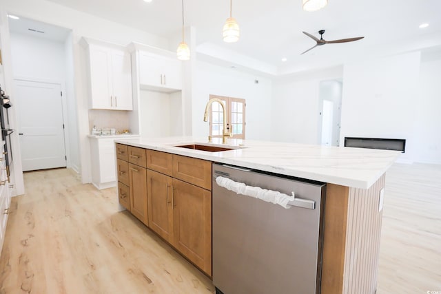 kitchen with sink, dishwasher, white cabinetry, light stone countertops, and an island with sink