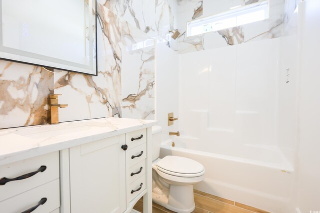 full bathroom featuring washtub / shower combination, backsplash, vanity, wood-type flooring, and toilet