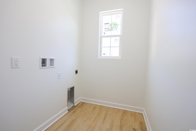 clothes washing area with light hardwood / wood-style floors, hookup for a washing machine, and electric dryer hookup