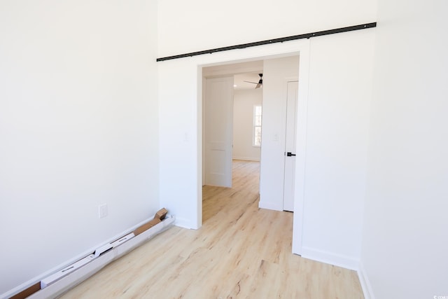 empty room featuring a baseboard radiator and light wood-type flooring