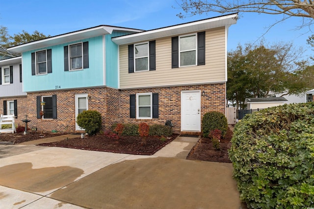 view of front of property with brick siding and a patio area