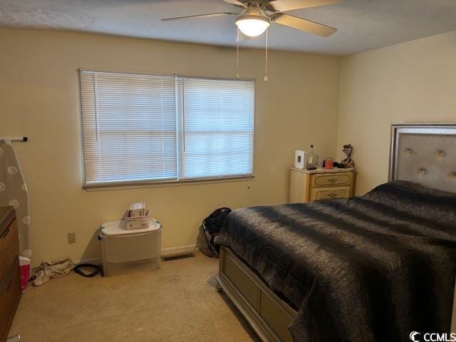 bedroom with light carpet, ceiling fan, and baseboards