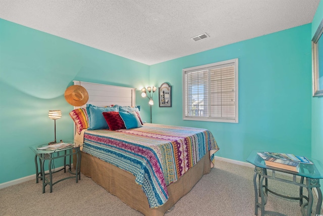 bedroom featuring light carpet and a textured ceiling