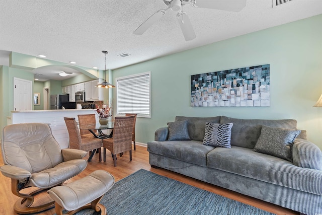 1900 Duffy St Unit C-7, North Myrtle Beach, SC 29582 - living area with light wood-style floors, arched walkways, a textured ceiling, a ceiling fan, and visible vents