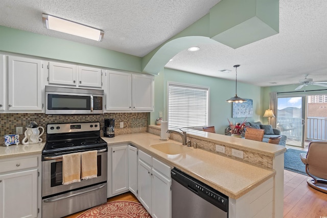 1900 Duffy St Unit C-7, North Myrtle Beach, SC 29582 - kitchen with a peninsula, a textured ceiling, appliances with stainless steel finishes, and open floor plan