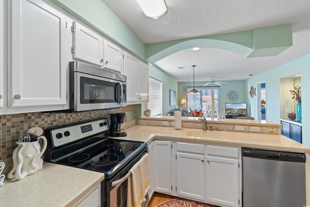1900 Duffy St Unit C-7, North Myrtle Beach, SC 29582 - kitchen with white cabinets, appliances with stainless steel finishes, a sink, light countertops, and a peninsula