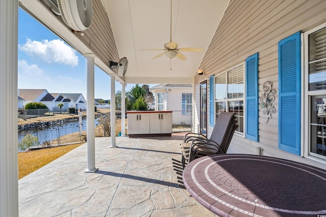 view of patio with ceiling fan and a water view