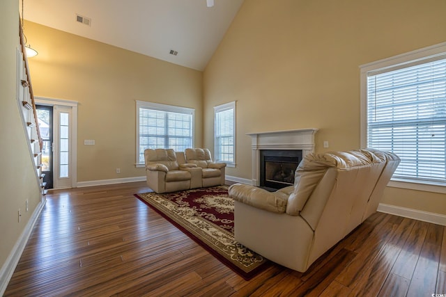 living room featuring plenty of natural light, dark hardwood / wood-style floors, and high vaulted ceiling