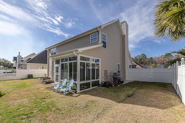 back of house featuring a sunroom and a lawn