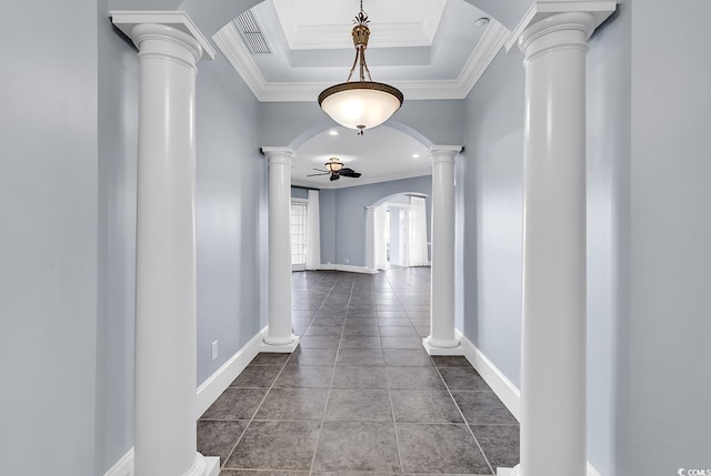 corridor with decorative columns, crown molding, tile patterned floors, and a tray ceiling