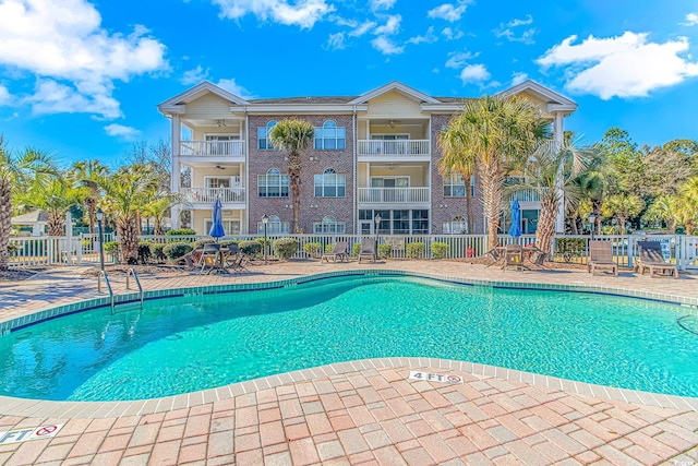 view of swimming pool featuring ceiling fan and a patio