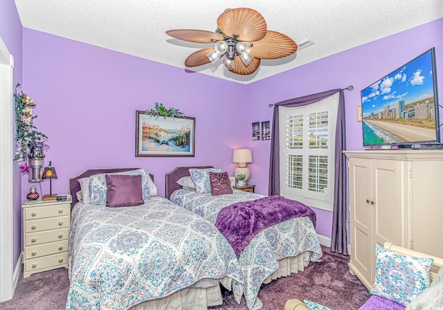 bedroom with ceiling fan, carpet flooring, and a textured ceiling