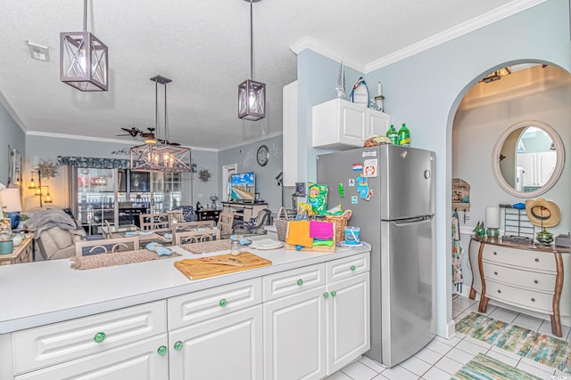 kitchen featuring white cabinetry, decorative light fixtures, and stainless steel refrigerator