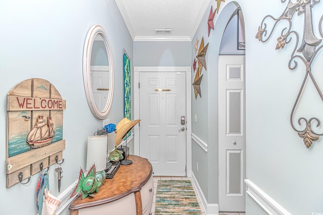 doorway with crown molding, tile patterned floors, and a textured ceiling