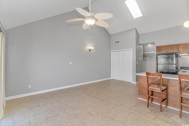 kitchen featuring a ceiling fan, visible vents, baseboards, light countertops, and freestanding refrigerator