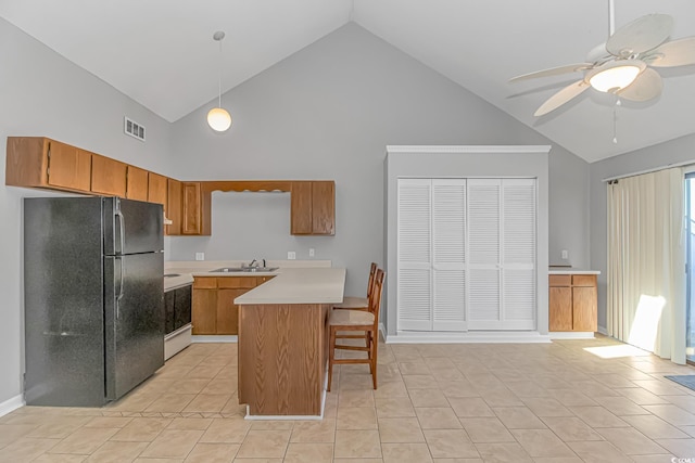 kitchen with white electric range oven, visible vents, freestanding refrigerator, light countertops, and a sink