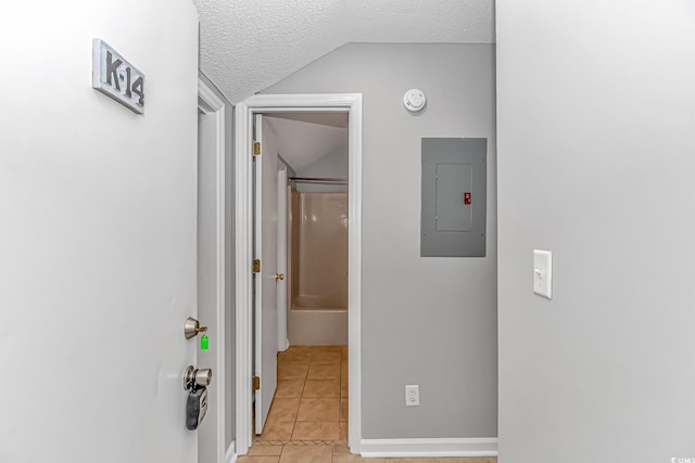 corridor featuring lofted ceiling, electric panel, a textured ceiling, and light tile patterned flooring