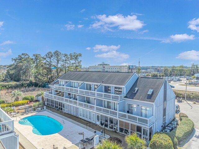 back of house with a fenced in pool, a patio, and a balcony