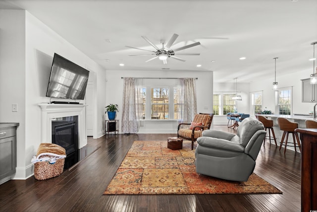 living room with dark wood-type flooring and ceiling fan