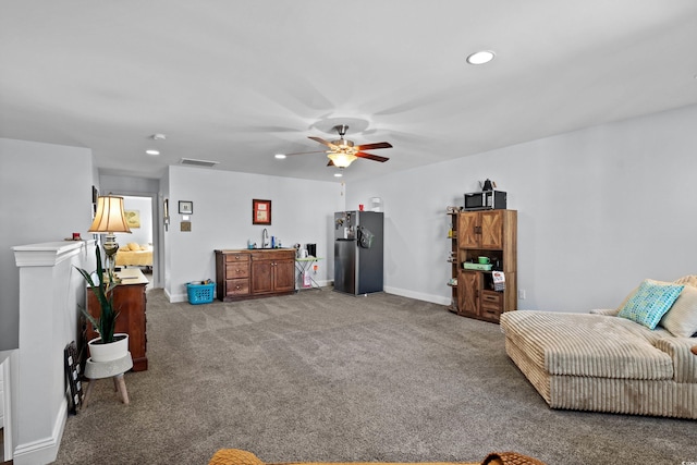 sitting room featuring ceiling fan and carpet floors