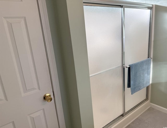 bathroom with baseboards and a shower stall