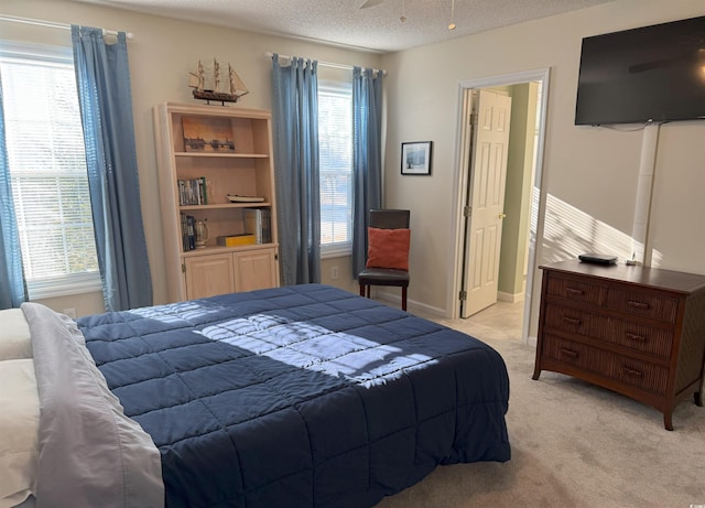 bedroom featuring a textured ceiling, multiple windows, and light carpet