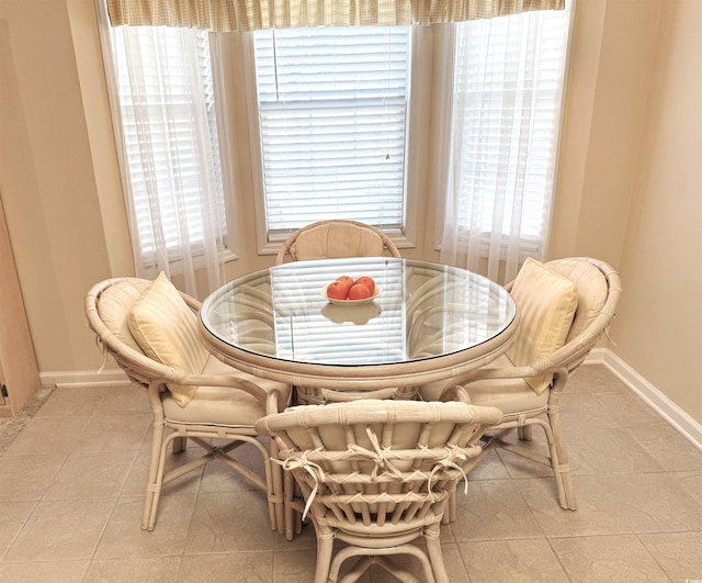 dining space with light tile patterned floors and baseboards