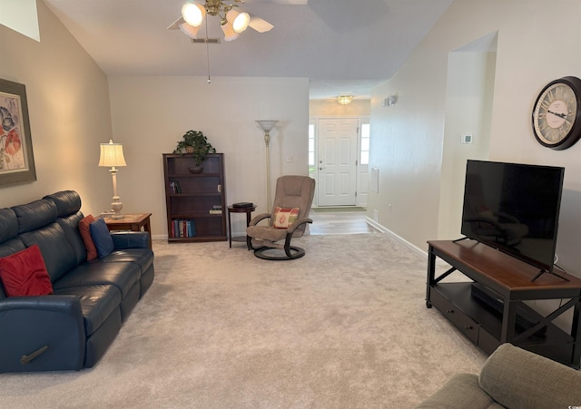 living area with light colored carpet, baseboards, and a ceiling fan