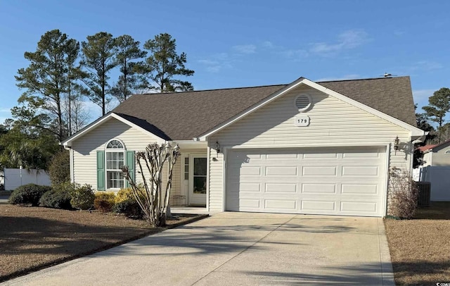 ranch-style home featuring an attached garage, a shingled roof, and driveway