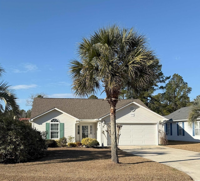 ranch-style home featuring concrete driveway, an attached garage, and a shingled roof