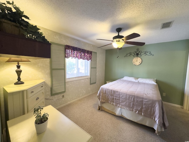 bedroom with ceiling fan, carpet flooring, and a textured ceiling