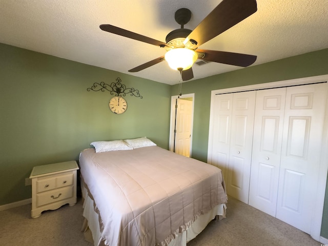 carpeted bedroom featuring ceiling fan, a closet, and a textured ceiling