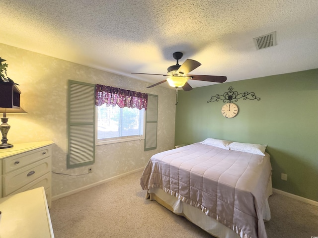 carpeted bedroom with ceiling fan and a textured ceiling