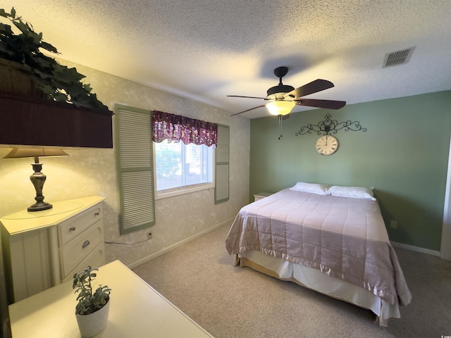 carpeted bedroom with ceiling fan and a textured ceiling