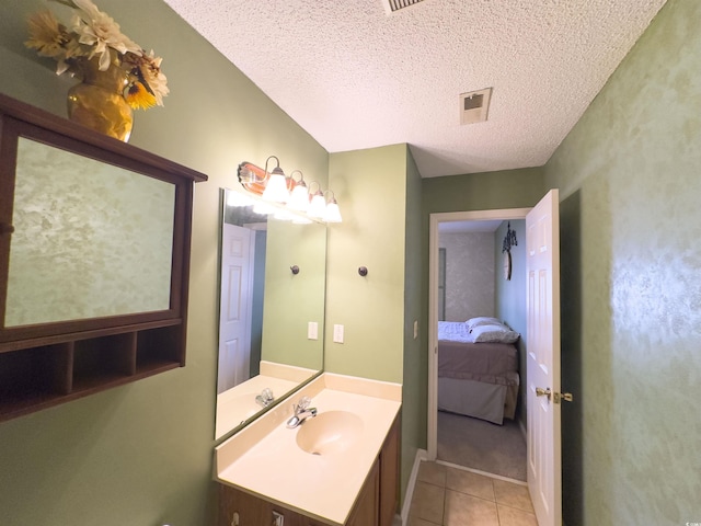 bathroom featuring tile patterned flooring, vanity, and a textured ceiling