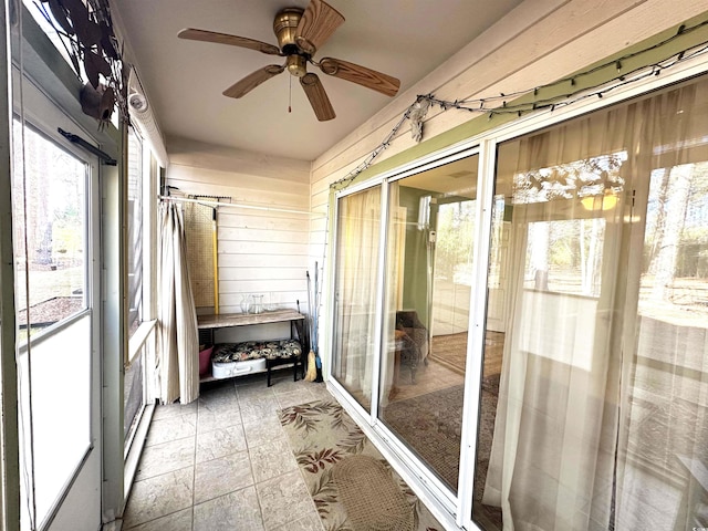 unfurnished sunroom featuring ceiling fan