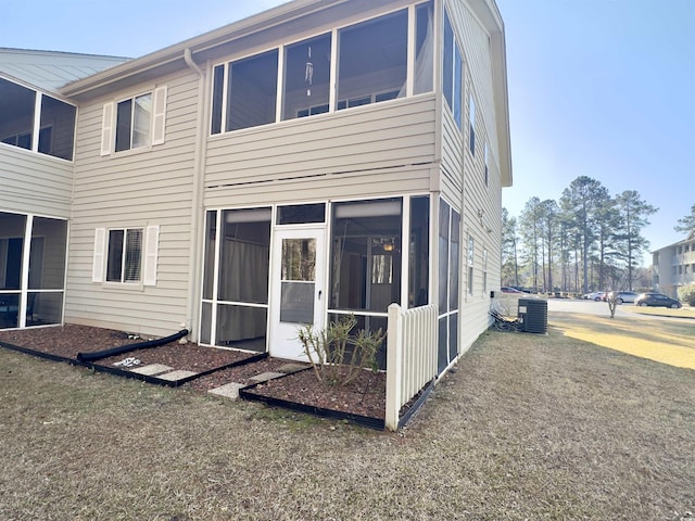 rear view of house with a sunroom and a lawn