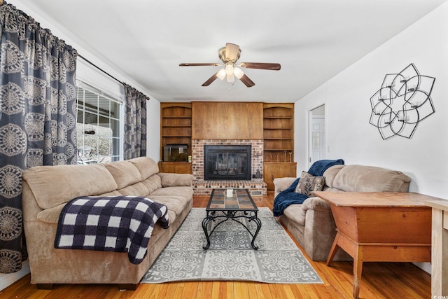 living room with hardwood / wood-style floors, a fireplace, and built in features