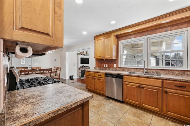 kitchen featuring dishwasher, stove, sink, and light tile patterned floors