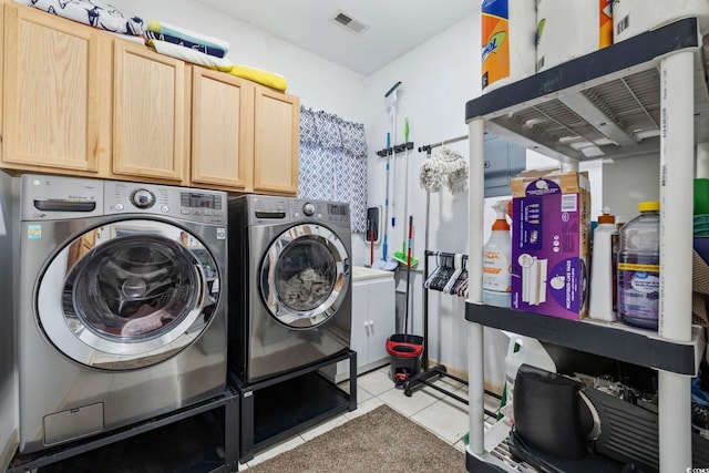 laundry area with light tile patterned flooring, cabinets, and washing machine and dryer