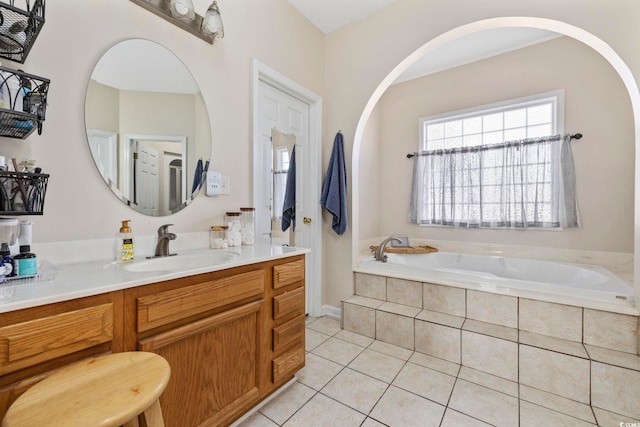 bathroom featuring tile patterned floors, tiled bath, and vanity