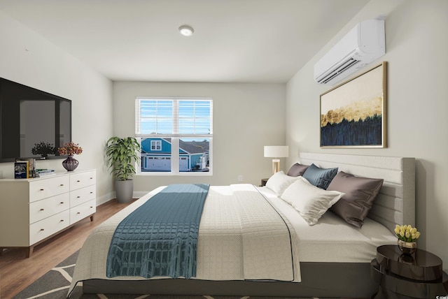 bedroom with a wall unit AC, baseboards, and wood finished floors
