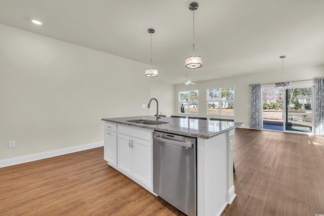 kitchen featuring a sink, white cabinetry, open floor plan, stainless steel dishwasher, and a center island with sink